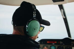 Pilot wearing headset, navigating aircraft cockpit with focus on aviate and aviation control.